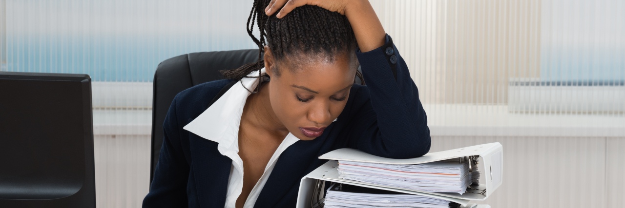 woman sitting at her desk looking stressed