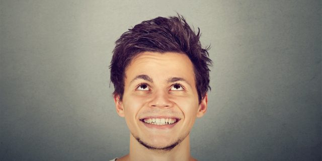 'Mommy, That Little Boy Has a Beard!' Portrait handsome smiling young man looking up