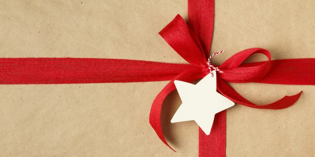 A close-up of a Christmas gift with a red ribbon and bow on top.