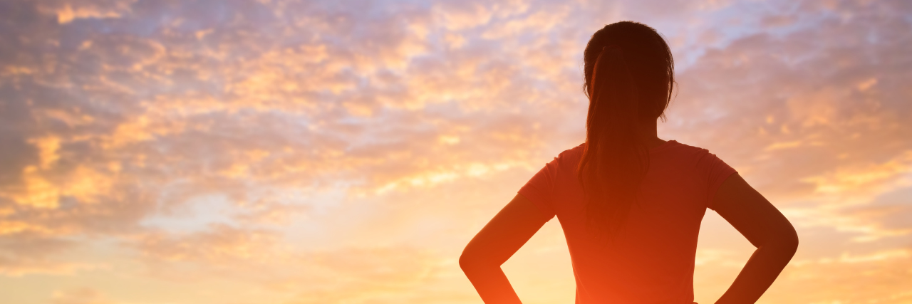 Improving My Body Image by Talking About My Cerebral Palsy Silhouette of woman at sunrise.