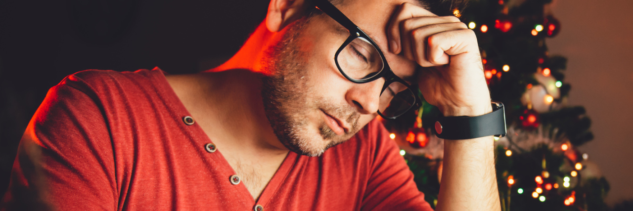 An Unexpected Gift: Recovering from Borderline During the Holidays man in red shirt in front of computer at Christmas depression tired