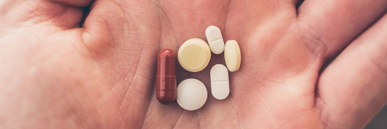 Weaning Off the Painkillers I'm Taking for Mitochondrial Disease person holding medications in their hand