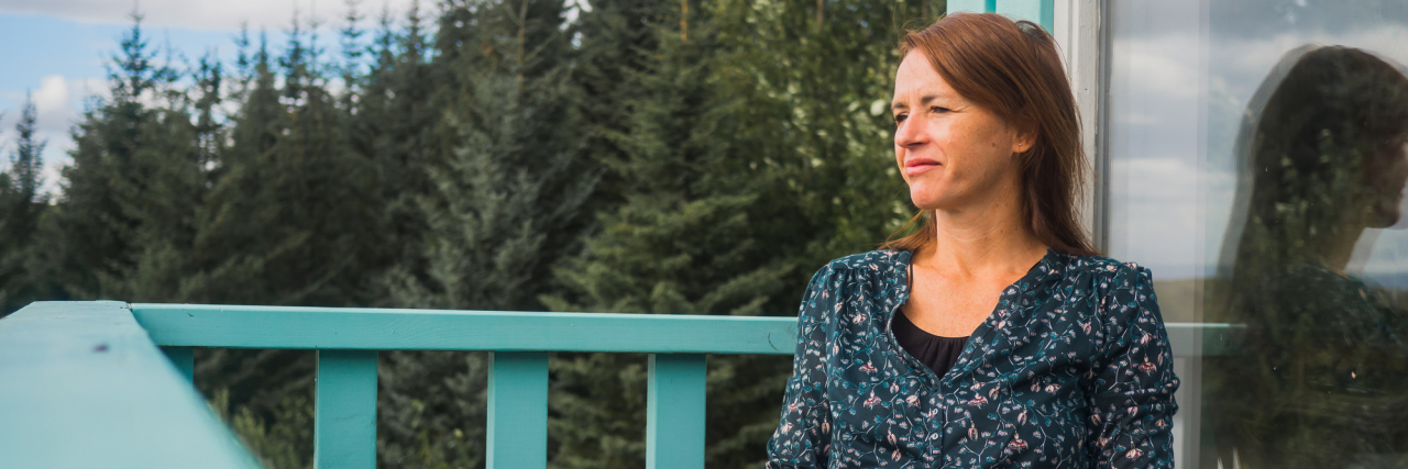 Planning for the Unexpected With Fibromyalgia woman sitting outside on a deck in a forest