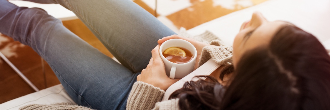 woman sitting on the couch drinking tea