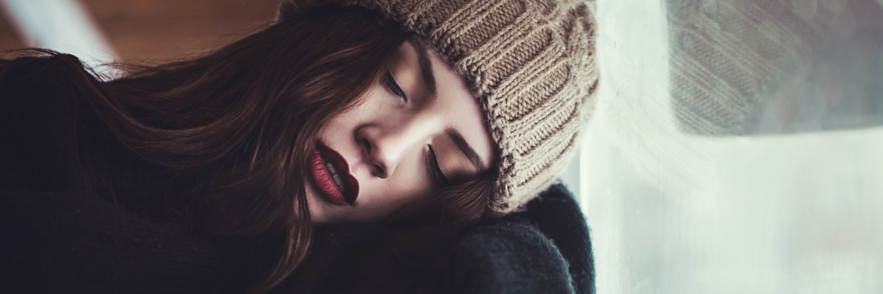 young woman sleeping infront of window