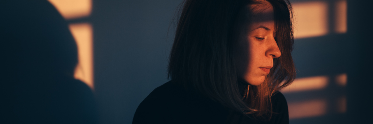 Why Relapses Have Been an Important Part of My Bipolar Recovery A woman sitting alone and depressed in window light