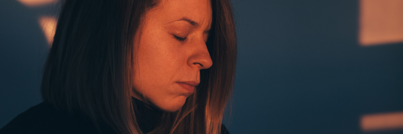 Living With Both Autism and Borderline Personality Disorder Woman alone looking depressed in light from window sunset