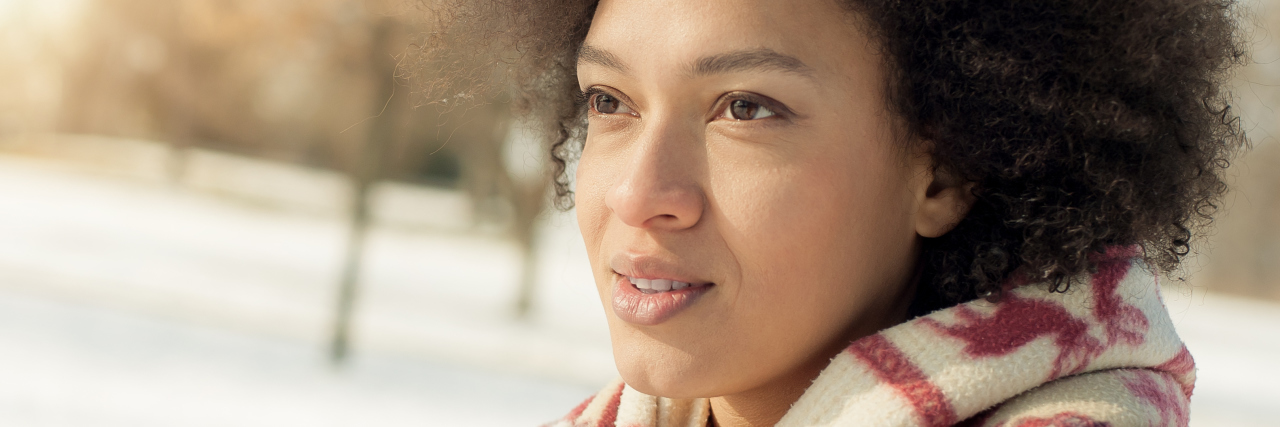 What Someone With Chronic Pain Wants for the Holidays woman standing outside in the snow with a blanket