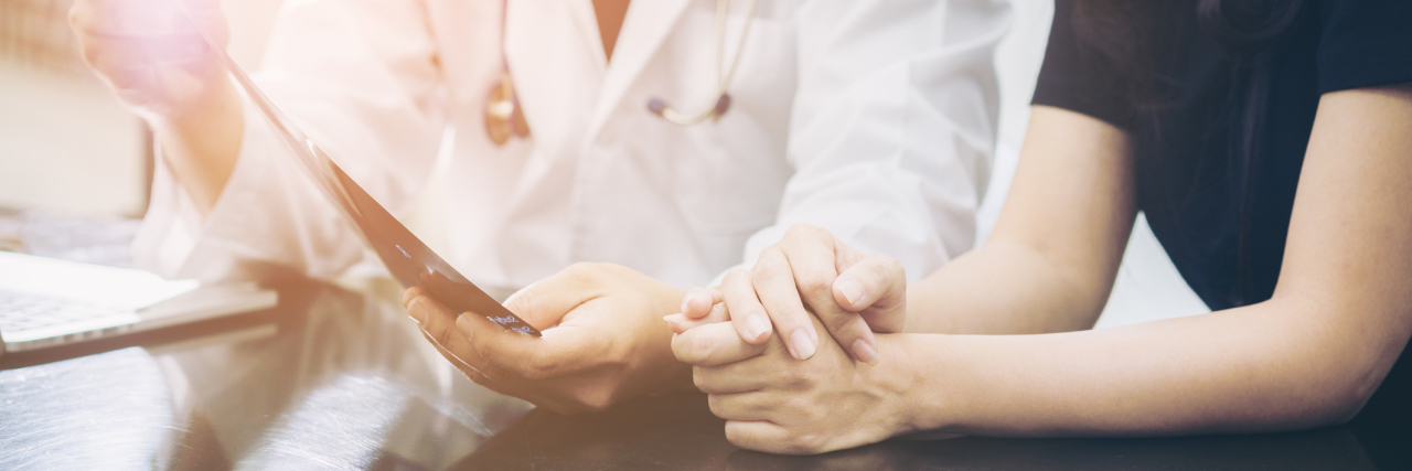 To the Doctor Who Has a Patient With Undiagnosed Illness Doctor and patient consulting on a table about women health. Medical concept. Selective focus at patient's hands.