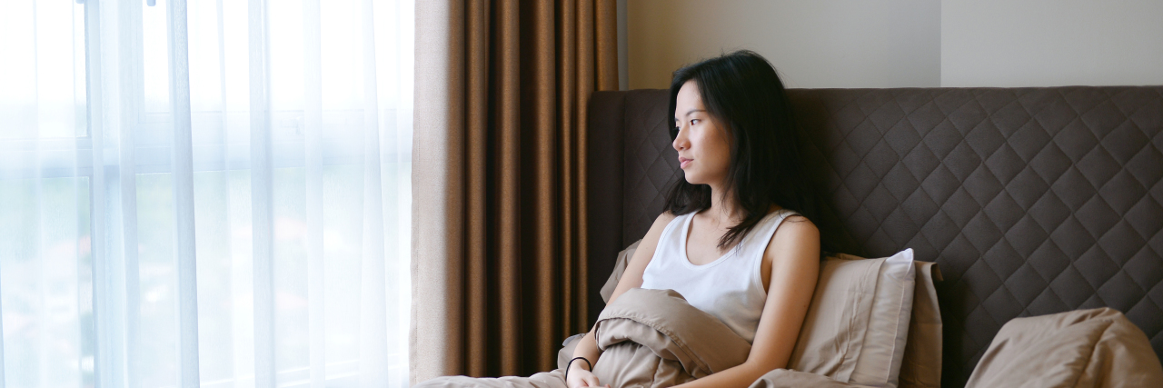 Dear Loved Ones, This Is Why Mental Illness Made Me Resign From My Job sad depressed woman thinking on bed in luxury bedroom