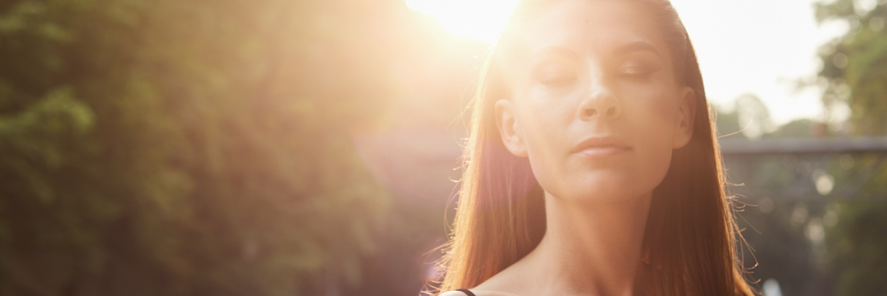 How to Deal With Post-Traumatic Stress Disorder Trauma Triggers woman in public near trees with eyes closed