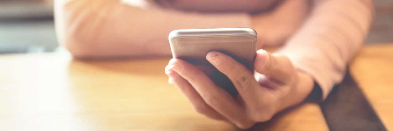 What It's Like Being on the Other Side of the Phone Call About Cancer Happy man using smartphone at modern coffee shop.