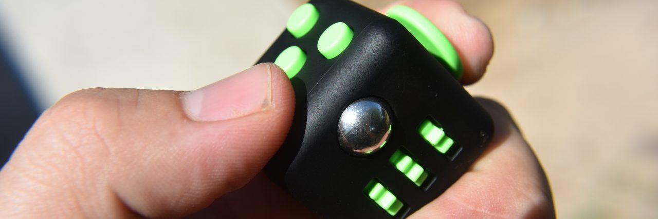 To the Person Who Got My Fidget Cube Taken Away in Class A photograph of a fidget cube.
