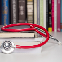 A stethoscope on top of medical books.