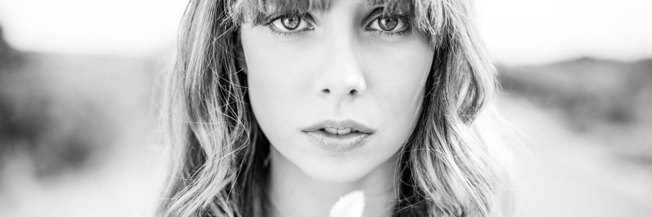 What Happens After a Borderline Personality Disorder Diagnosis black and white photo of blonde woman holding small leaf and looking at camera