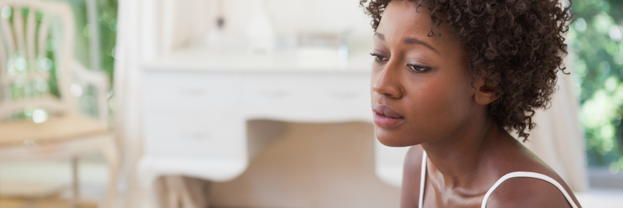 thoughtful pensive woman sitting on bed