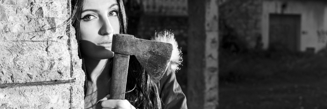 Hollywood Thinks My Dissociative Identity Disorder Makes Me 'Crazy' black and white photo of woman with axe behind wall