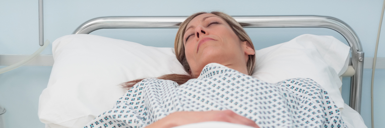 Woman sleeping on a bed in hospital ward