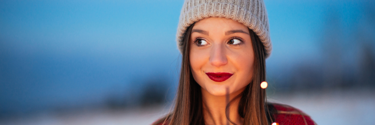 The New Year's Resolution I'm Making for My Anxiety woman with sparkler looking into distance