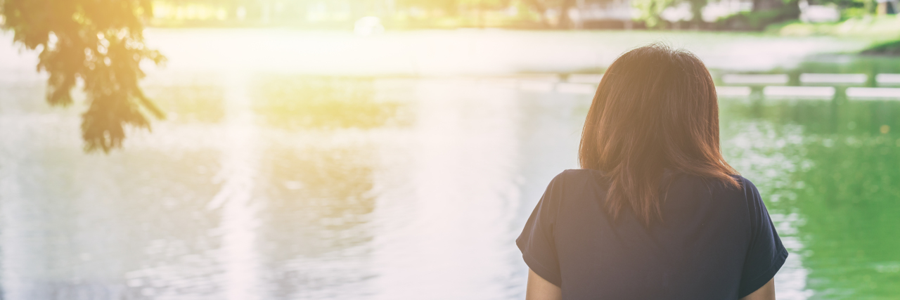 The Day I was Diagnosed With a Rare Lung Disease woman sitting alone feeling lonely and thinking missing someone looking out at water lake