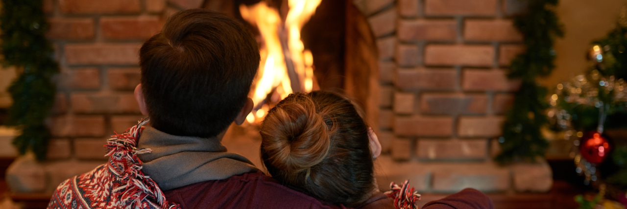 husband and wife around a christmas fire