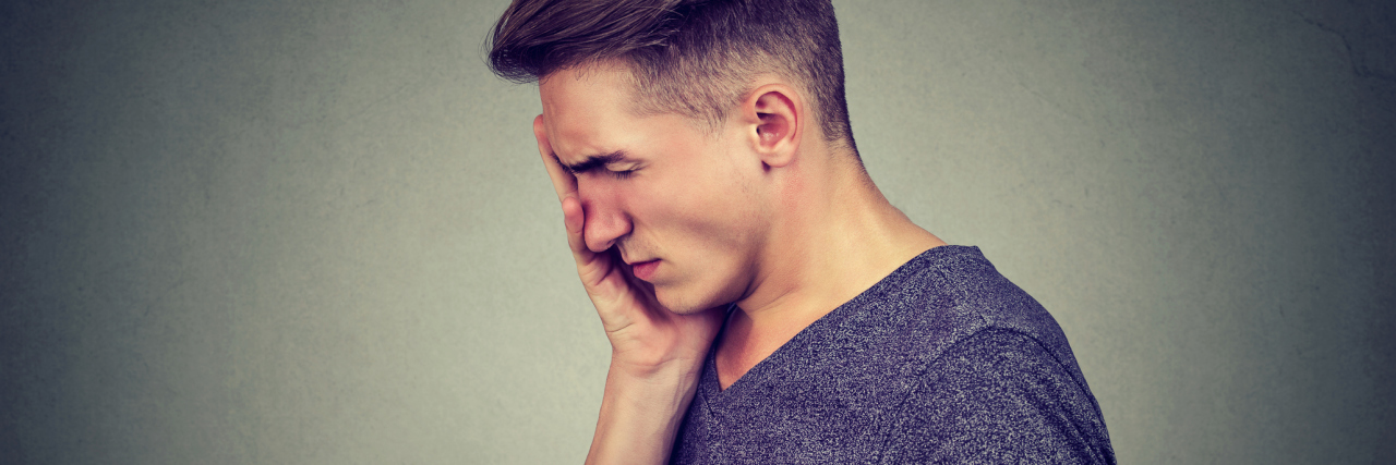 The 2 Things I Wish People Didn't Say About My Depression young man side view with worried expression face in hand