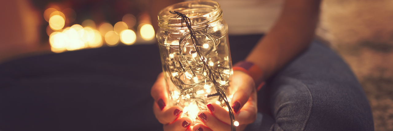 Woman holding a jar full of lights