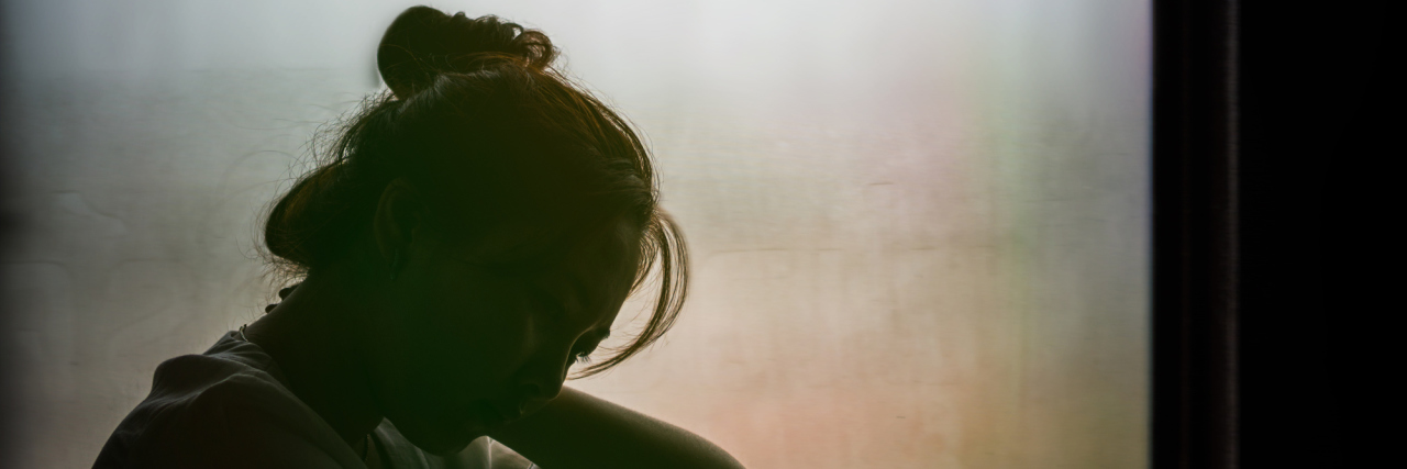 Another Day of Waking Up in Pain A silhouette image of a woman with her face in her hand.