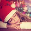 Teen girl sleeping near Christmas tree
