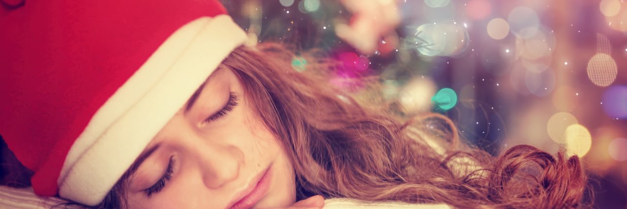 Teen girl sleeping near Christmas tree
