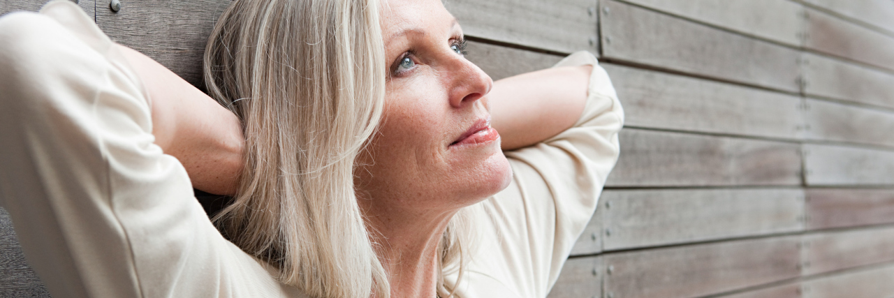Practicing Positivity in the New Year as a Chronically Ill Caretaker older woman leaning against a wall
