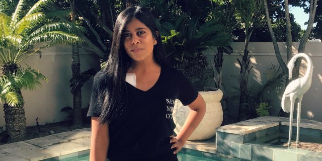 The Symptoms You Don't See When You Say I Don't 'Look Sick' A photo of the writer standing in front of a pool.