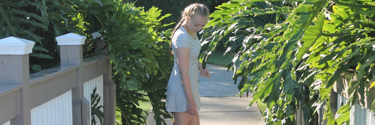 What Happens If Doctors Give Up on Treating My Migraines? woman standing on a path outside between plants