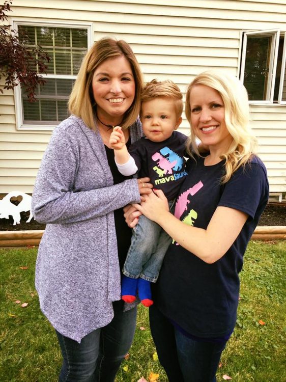 two women holding a boy on his first birthday