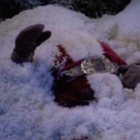santa lying on the ground covered in snow
