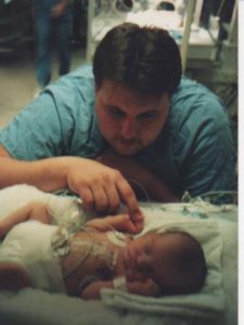 father looking at baby daughter in the hospital