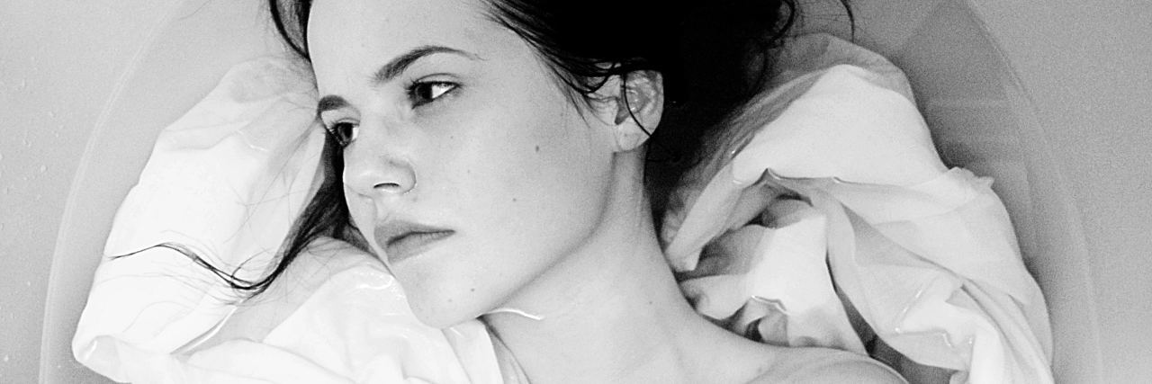 What You Need to Know About Why People Self-Harm young woman in bath looking lost or distraught away from camera