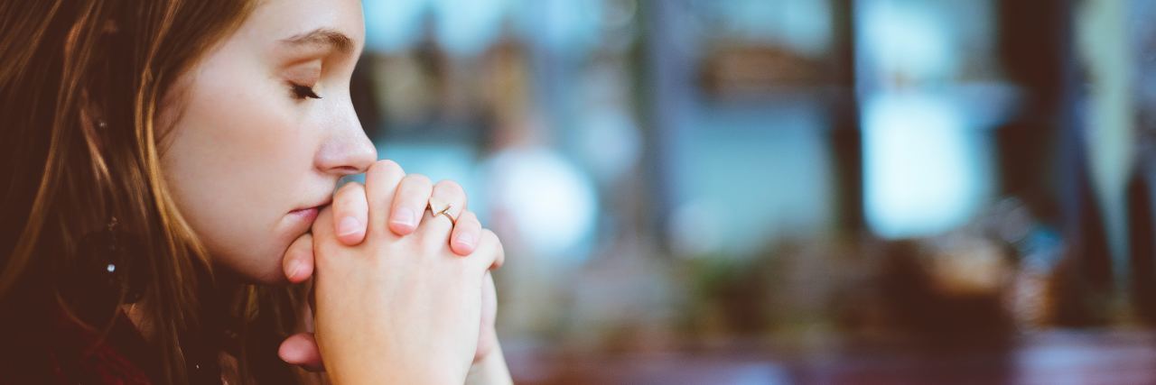 The Mantra I Used to Conquer a Relapse in Anorexia Recovery a woman sits on a bench contemplating