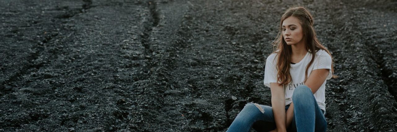 How Rejection Sensitive Dysphoria Affects Me as a Person With ADHD woman alone on beach or rocky ground