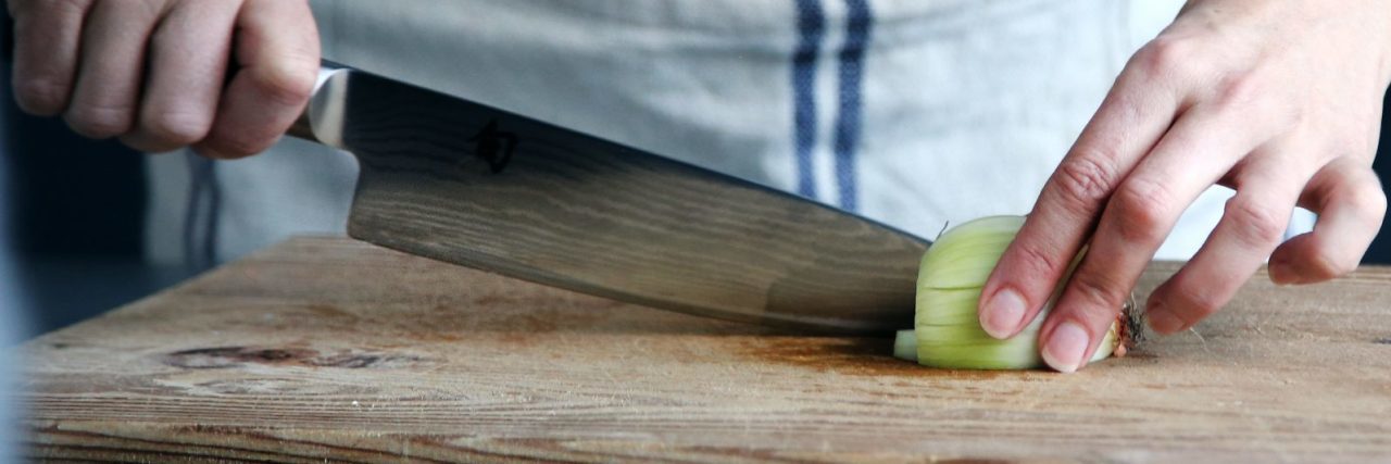 My Harm OCD Treatment for Intrusive Thoughts With Knives woman cutting onion with sharp knife on chopping board