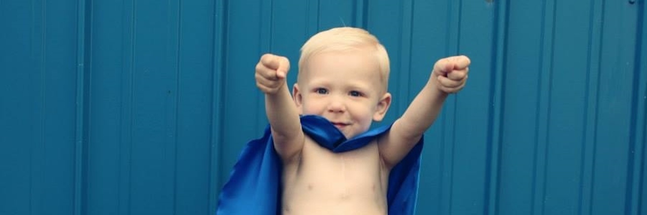 Little boy with blue super hero cape