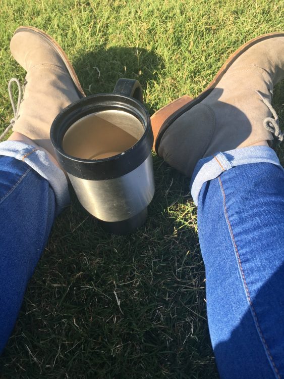 photo of woman's feet and a cup of coffee