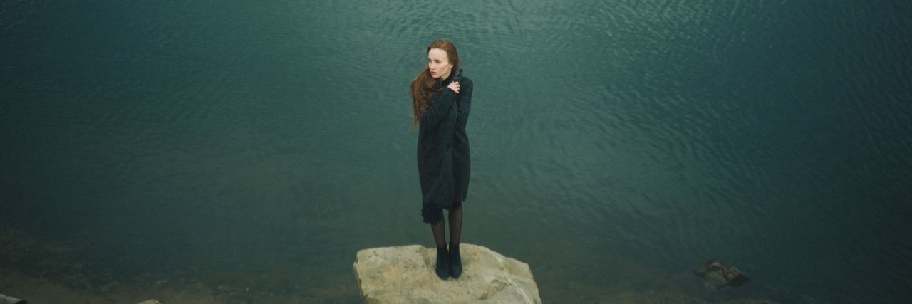 What Two Years of Persisting Through Depression Has Taught Me woman standing on rock with ocean behind her