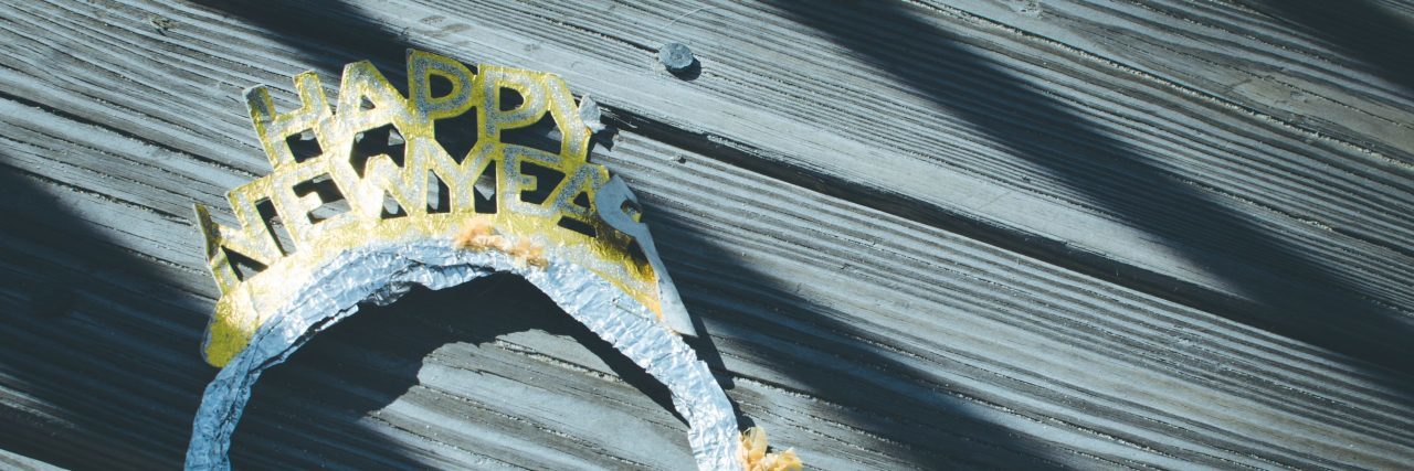 Why My Mental Health Means I Don't Make New Year's Resolutions happy new year tiara on wooden deck or floor