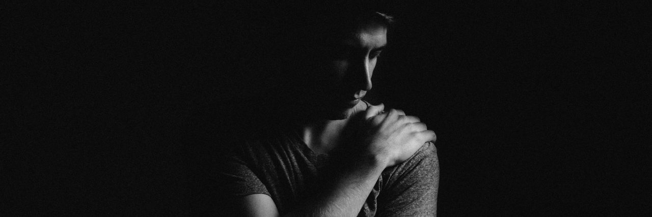 How the Shame Accompanying Depression Was Secretly Ruining Me black and white photo of man holding self in darkness