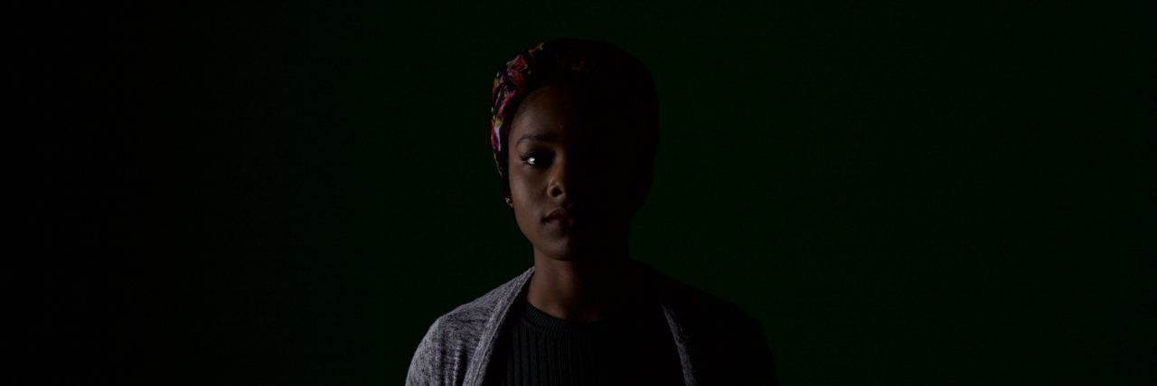 african american woman stands in a dark room