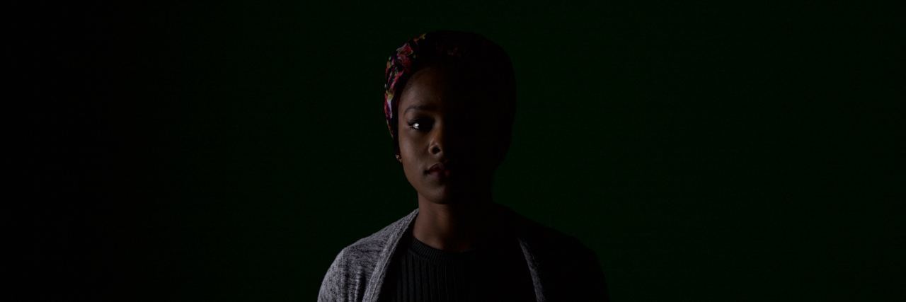 What I Didn't Know About Depression Until I Faced It Myself african american woman stands in a dark room