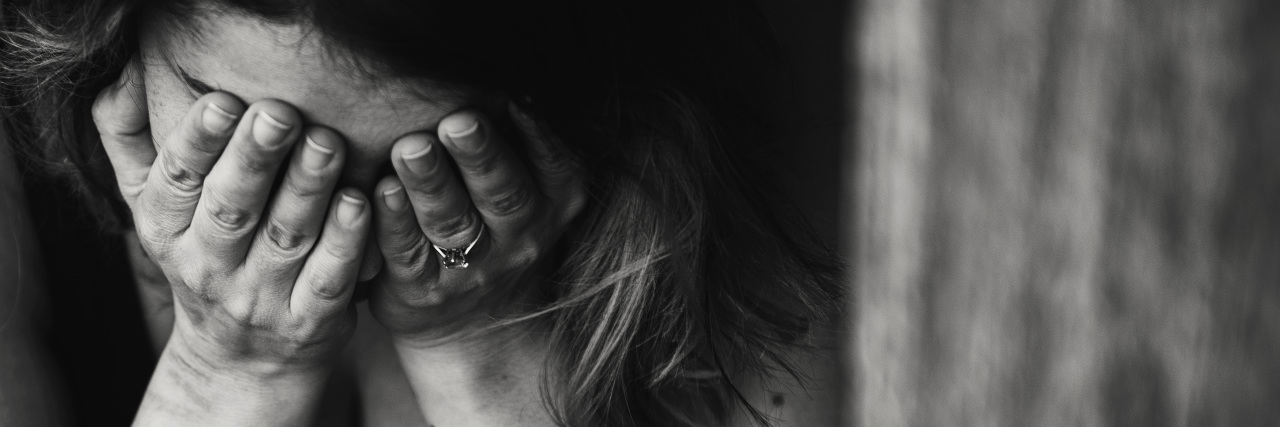 black and white image of woman holding her face in her hands