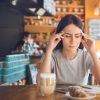 woman getting a migraine at a restaurant