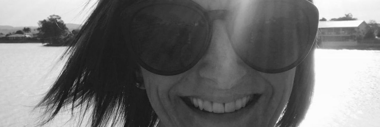 What I Want People to Know About the Anxiety Hiding Behind My Smile black and white photo of woman smiling into camera